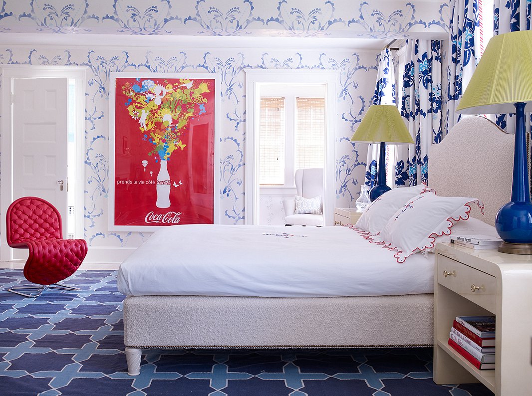 Designed for one of the family’s children, this bedroom features hand-stenciled walls. The French Coca-Cola poster and the curvy red chair ensure that the room doesn’t feel overly traditional.
