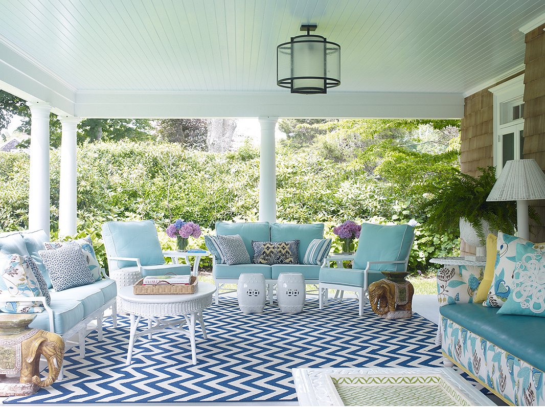 The blues and whites of the porch’s sitting area mimic those seen throughout much of the interior—and of course, the colors of the nearby ocean. The Kelly Garden Stool is similar to the white stools shown here.
