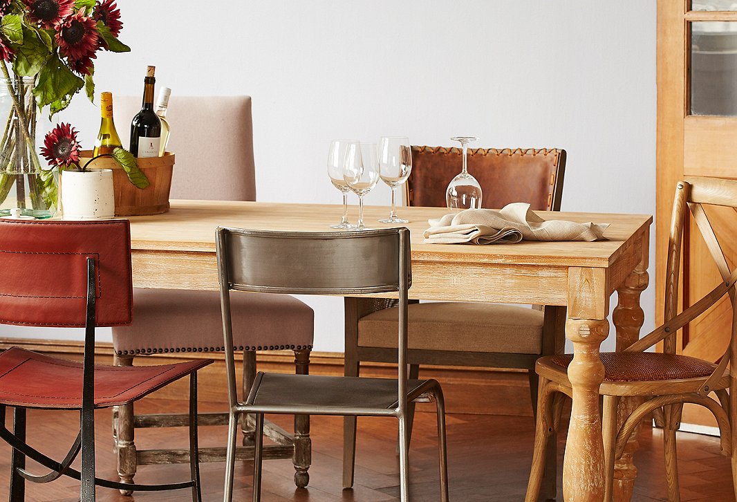 Why match when you can mix? Not only are the chairs different styles, but they’re also made of different materials. The brown-and-beige palette keeps the look cohesive. And what could be more Mediterranean than using a rustic basket to hold a few bottles of wine?
