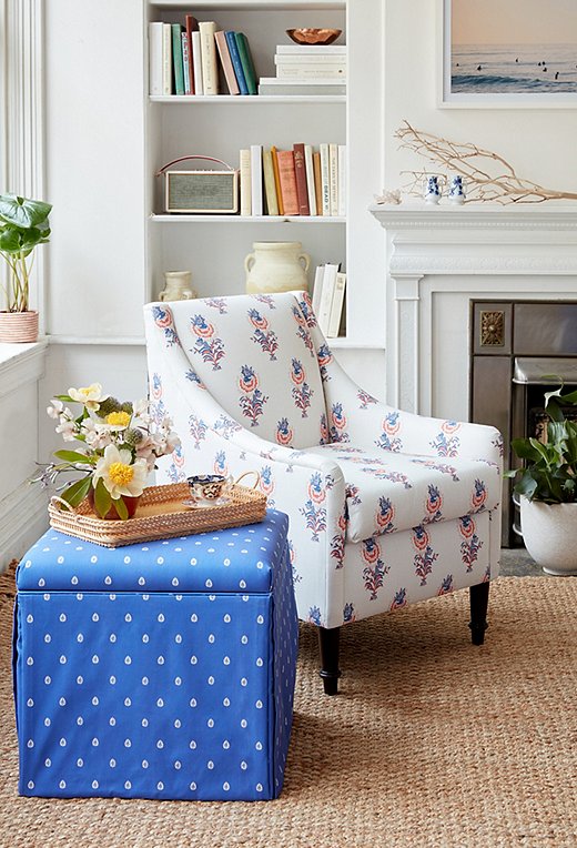 The larger scale of the Desert Flower print in lapis/coral on an accent chair pairs perfectly with the petite dots of the Mariposa skirted storage ottoman. 
