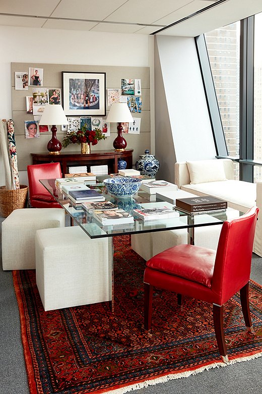 A set of petite ottomans and a pair of Ralph Lauren Home Lawson Chairs, upholstered in red leather, surround the glass conference room table. Against the windows, a linen settee offers an additional spot to sit during meetings or to work solo. “The idea that you can sit in the middle of the day, have a view of Central Park, and maybe have a few sips of coffee is comforting,” Stellene says. 
