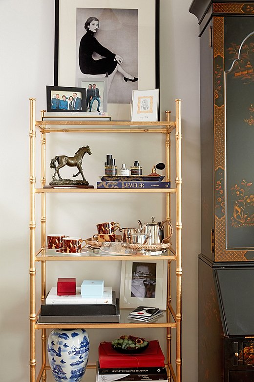 Stellene’s daily essentials and personal mementos fill the gilded étagères flanking the secretary, including fragrances from Frédéric Malle (“I’m never far from a bottle of Promise or Portrait of a Lady,” she says), a tea set gifted by Ralph Lauren Home when she became editor-in-chief, copies of her book on jewelry, and framed family photographs. 
