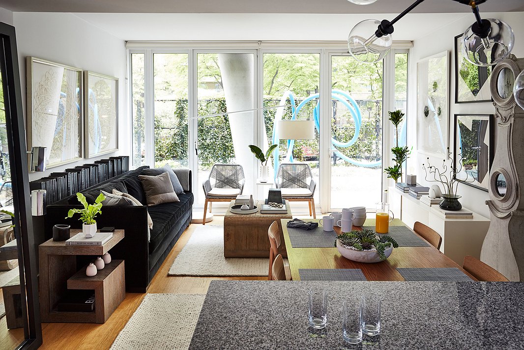 The woven chairs against the windows echo the modernist angled lines on the facade of the building, a concrete pillar of which can be seen in the background in the building’s private garden. 
