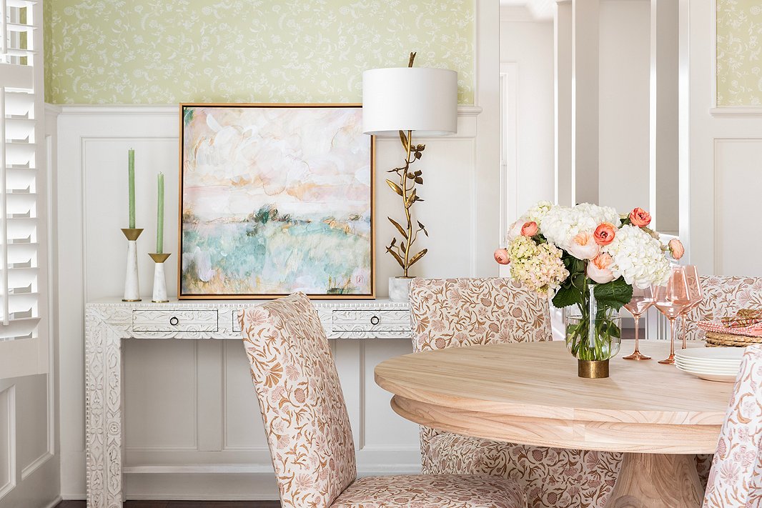 The Owen Slipcover Chairs and the Farrow & Ball wallpaper (Uppark BP 577) keep the dining room feeling bright and spring-fresh year-round. The carvings on the Violet Console echo the floral motifs. Find the candleholders here, the Laura Roebuck artwork here, and the dining table here. 
