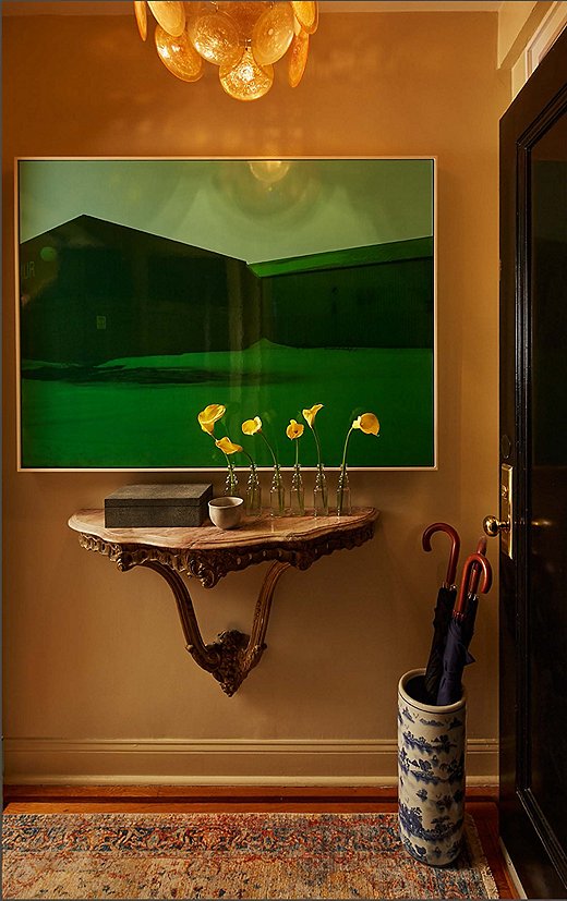 “We tried to make it a moment,” Philip says of the apartment’s petite entry. “The acid-green painting is shocking when you open the door, but it’s only for a second, and then you move into the rest of the space.” The art contrasts with the marble-top French console below, on which a faux-shagreen box holds keys and dog leashes to be quickly grabbed before walking out the door. 
