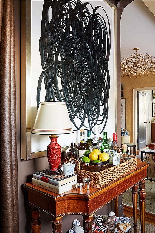 The dining alcove, which has been turned into a home office, features a well-stocked bar cart—an important addition given how much they entertain at home. 
