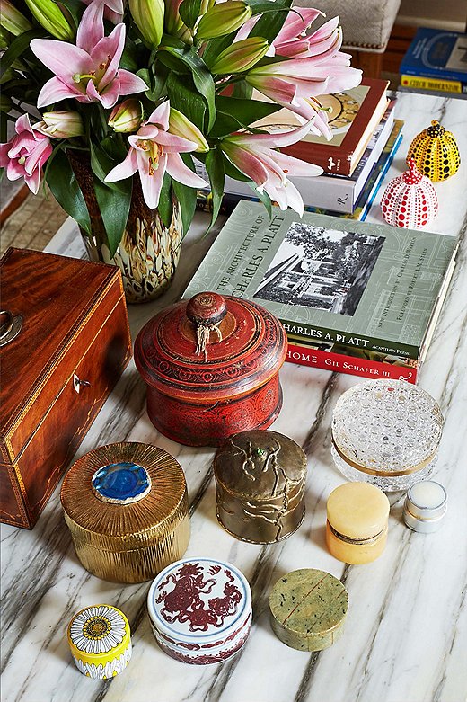 English marquetry and trinket boxes, along with a pair of Yayoi Kusama lacquered pumpkins, fill the coffee table in the living room. Occasionally Philip will clear everything off and use the table as a drawing board, since the room receives plenty of light. 
