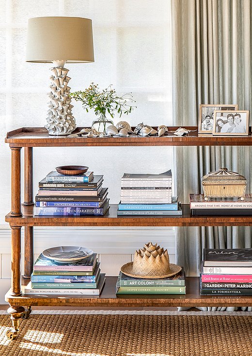 Antique pieces of furniture were the perfect solution for a space that needed smaller silhouettes. This antique étagère houses the client’s collection of silver-plated shells.
