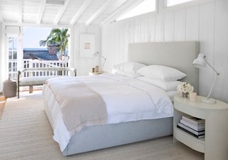 “We were going for a spalike atmosphere,” says Marea of the main bedroom. Bright light floods the shiplap-laden room. A custom wool rug provides comfort underfoot. “The pattern is almost like a fisherman’s sweater,” says Marea. The bed, upholstered in blue linen, is also custom.
