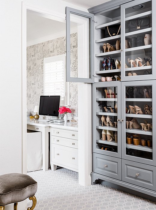 Painted gray for a touch of contrast, a glass-front cabinet in the master closet puts shoes and handbags on display.
