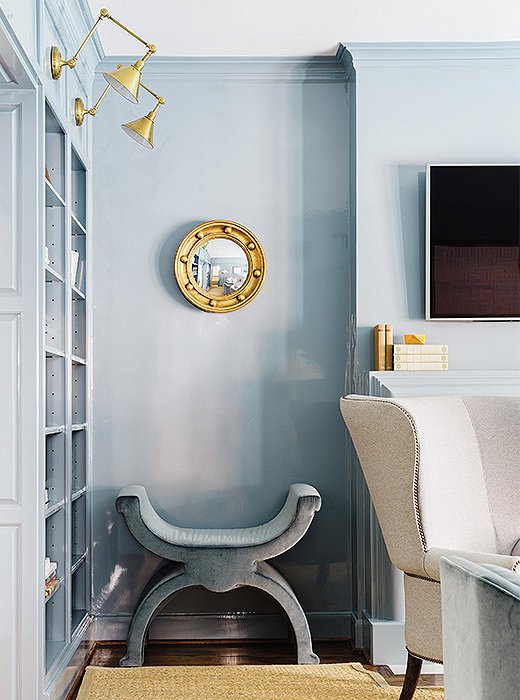 A gold mirror and brass lighting complement a cooler shade of blue.
