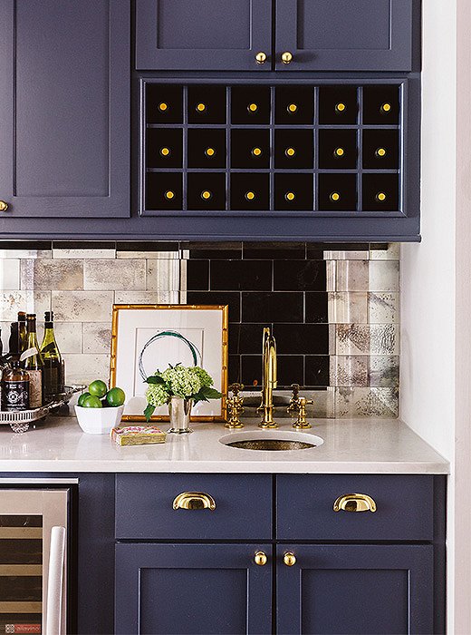 A mirrored-tile backsplash lends glamour to this wet bar.
