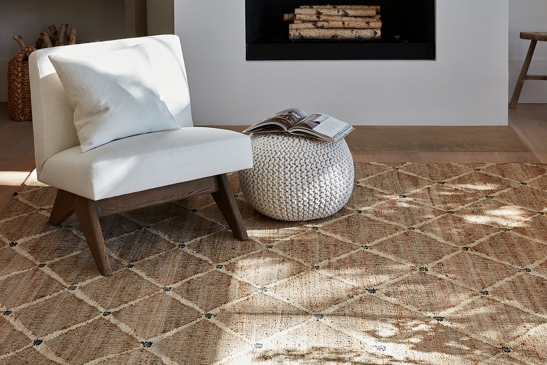 Handwoven of a jute blend, the Kali rug effortlessly brings organic texture as well as pattern to a room. The knitted Kelli pouf and the linen-upholstered Gillis chair are sympatico accompaniments.
