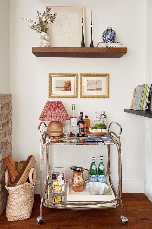 A bar cart is an entertaining essential in a small apartment. In keeping with her love of lighting, Samantha placed a petite lamp on the cart’s top shelf and added a shade made from a sari.
