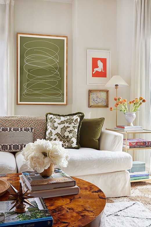The white slipcovered sofa serves as a blank canvas for pillows and throws in a variety of complementary colors and prints. More pattern comes via the layered rugs. Find the lumbar pillow here, the table lamp here, and a similar Moroccan-style rug here. 
