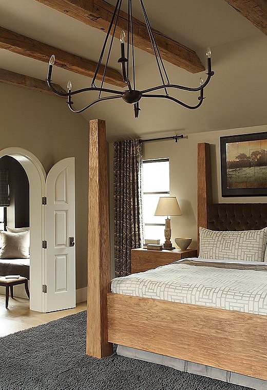 The couple wanted their master bedroom to feel like a cocoon, says Tish. The custom oak bed anchors the space in a stately manner while providing an interesting symmetry with the wood beams. The headboard is wrapped in a velvet fabric from Ralph Lauren, which Tish says feels like “a really yummy jacket.” 
 
