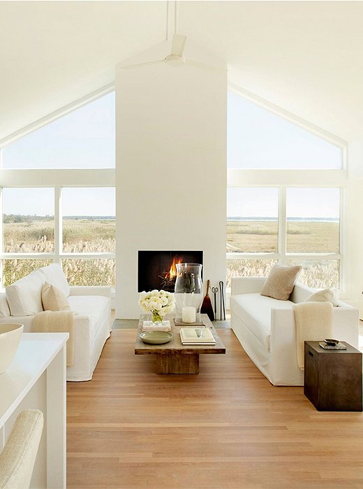 Two slipcovered sofas flank the living room’s fireplace, creating a layout as serenely structured as the house itself. A cement stool and an unfinished wood coffee table speak to Foley’s love of mixing textures and tones.
