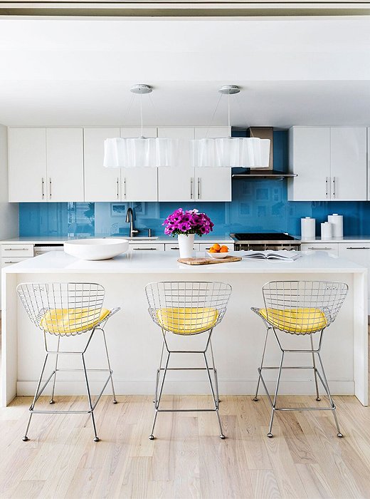 Touches of yellow and blue guide the eye toward the kitchen in the open-plan space.
