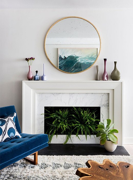 Geometry at play: A round mirror (similar to the Kylie wall mirror) softens the living room’s squared-off mantel.

