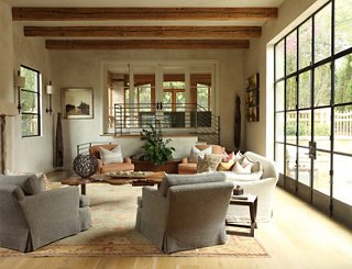 The living room exemplifies the couple’s kick-up-your-feet style. Plush sofas and chairs in neutral tones add softness to a space defined by its striking architectural elements.
