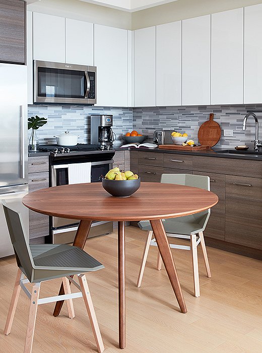 A walnut-finish dining table acts as a kitchen island as well as a place for Will to share meals with friends. Just shy of 40 inches in diameter, it was just the right size for the compact corner. 
