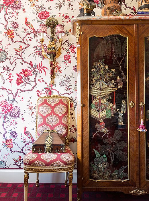 The Chinese armoire, found in London, features lacquered panels that add rich contrast to the upholstered walls.
