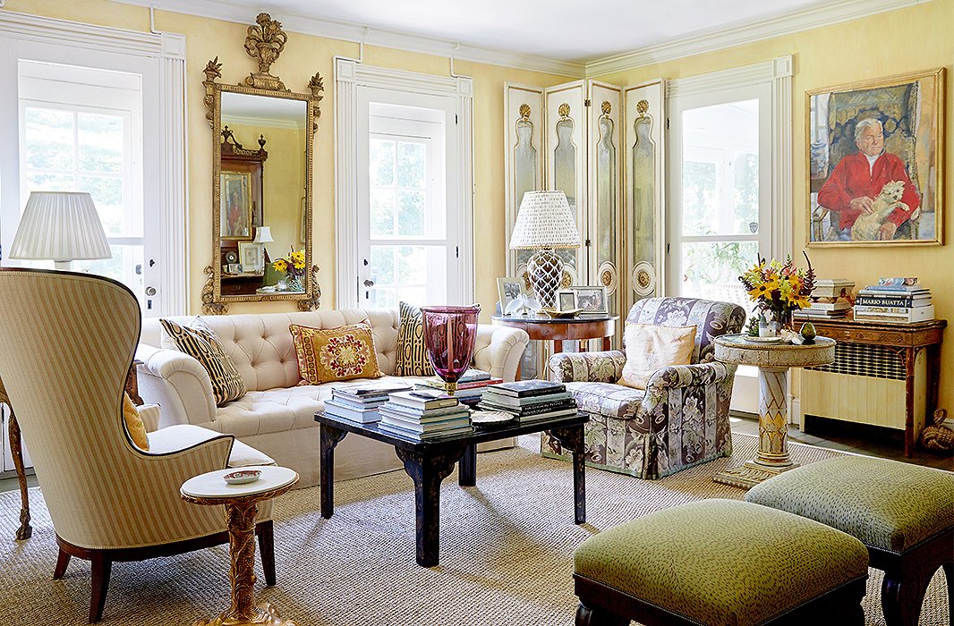 The skirted sofa and armchair help ground the room’s other furnishings. Find the table lamp here.  Design by Bunny Williams; photo by Tony Vu.
