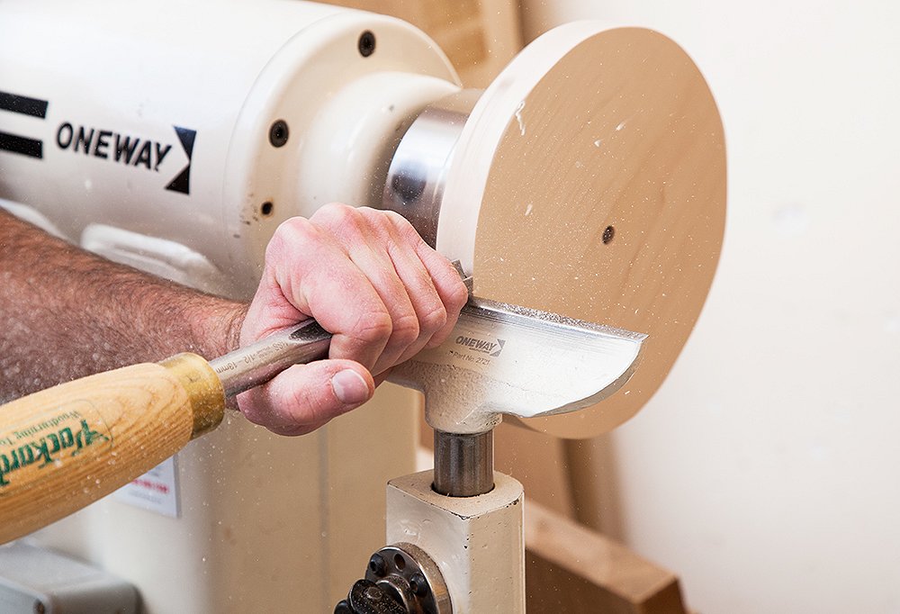 Once the lamps are out of the kiln and approved, a craftsman gets to carving a beautiful wood base.
