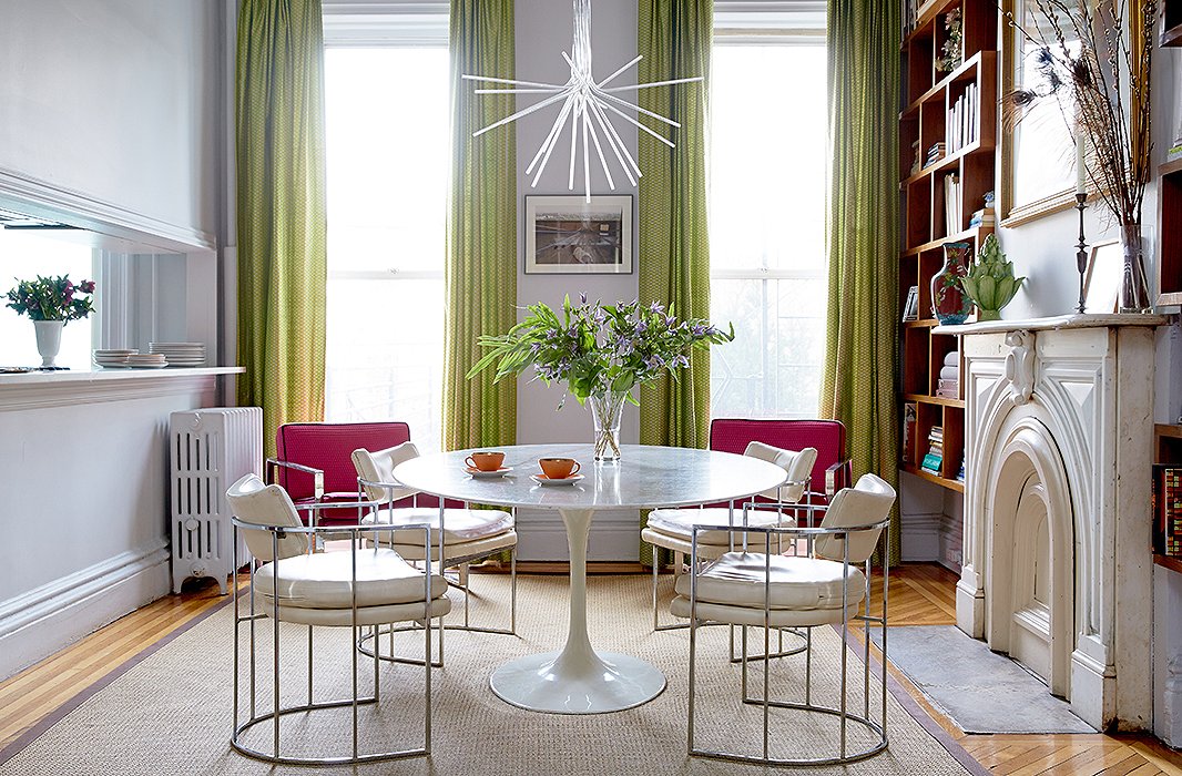 The dining room/library is a “hub” of the family home. That calls for durable pieces such as a sisal rug and a marble-top Saarinen Tulip table that works for dinnertime, homework, reading, and more. The chartreuse curtains (also in the living room) are from a textile not-for-profit in Southeast Asia.
