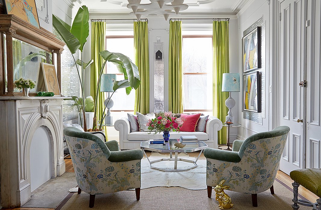 Trim in a rich, warm green velvet ensures that the floral pattern of the chairs feels appropriate even in winter. As well as contributing a tropical note, the towering plant draws the eye upward to the elaborate moldings. Photo by Tony Vu; design by Fawn Galli.
