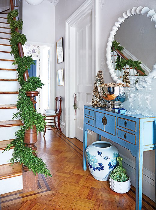 Curate your entryway with color. Here, the green garland sets off the space’s gorgeous shades of blue.
