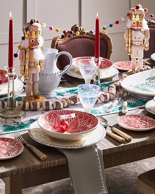 Set a playful scene with wares from Vietri’s holiday collection and nutcrackers draped in whimsical garlands. 
