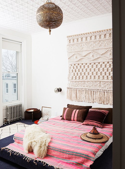 Key elements define the master bedroom: A built-in carpeted platform bed, and the rope wall hanging by Sally England is the first piece Julia ever commissioned.
