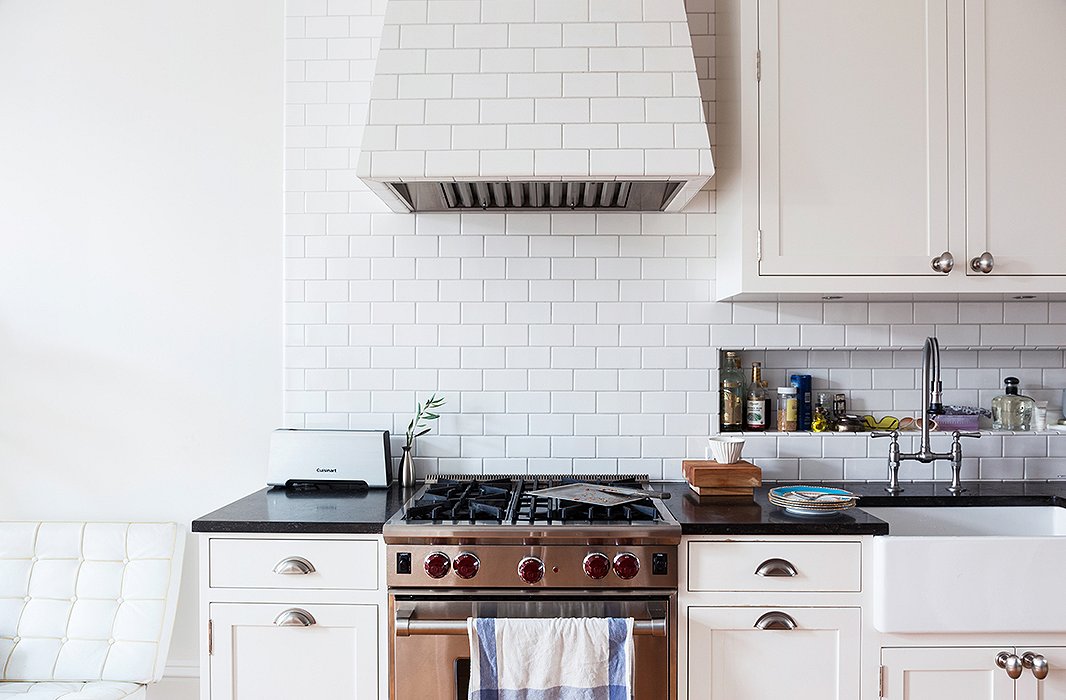 The seemingly out-of-place Barcelona lounge chair in the kitchen is intentional. “I like to subvert the idea of having to sit around a table,” says Julia. She calls it her “little perch,” a place to send emails, talk on the phone, and “nibble on toast.”
