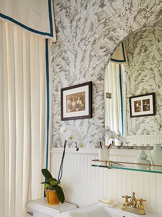 The pop of jewel tone on the custom shower curtain brings depth to the bungalow bathroom. The walls are covered in the iconic Florencecourt Wallpaper from Cole & Son.
