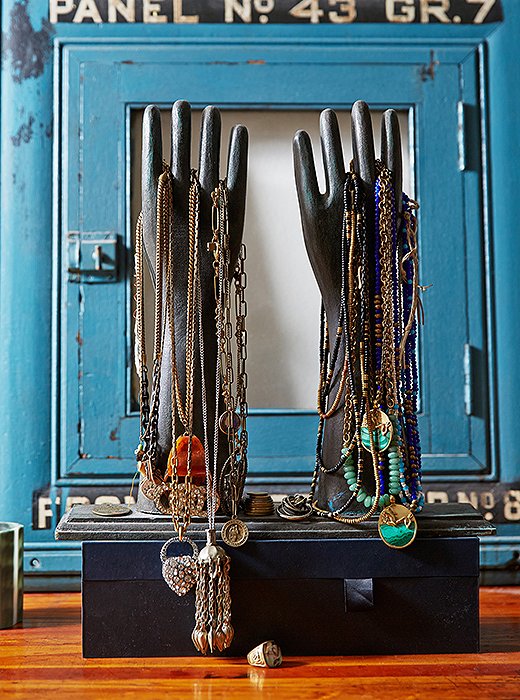 More necklaces are displayed on a pair of antique Indian wooden glove-making molds that Lisa picked up while traveling in Nepal. Behind them is a 1930s electric panel originally from the Con Edison building in New York City.
