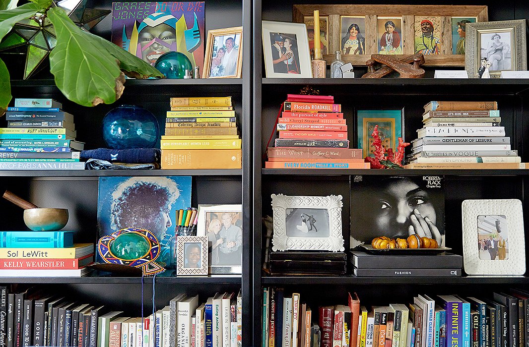 Their “happy bookshelf,” as Lisa likes to call it, is artfully arranged with color-coded tomes, favorite photos, old records, and pieces from their travels. “The colored markers I use to sketch and draw are on display too,” says Lisa. The framed piece on the top right shelf features several Native American portraits; Lisa got it in Montana when she was working there on a cattle ranch.
