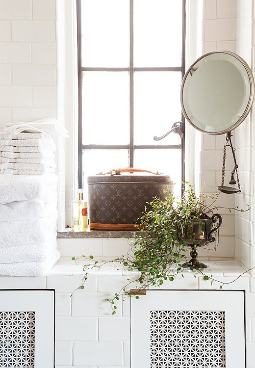 A clever tile built-in hides the formerly exposed radiator while adding storage. A trophy from Mardi Gras doubles as a planter, while the metal scale, a souvenir from Syria given to Smith by her journalist boyfriend, works as a jewelry catchall.
