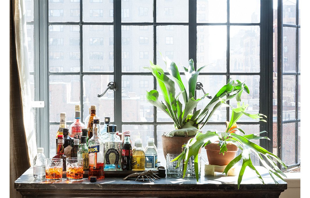 The kitchen island from Smith’s previous apartment is repurposed as a makeshift bar in the living room, ideal for entertaining.
