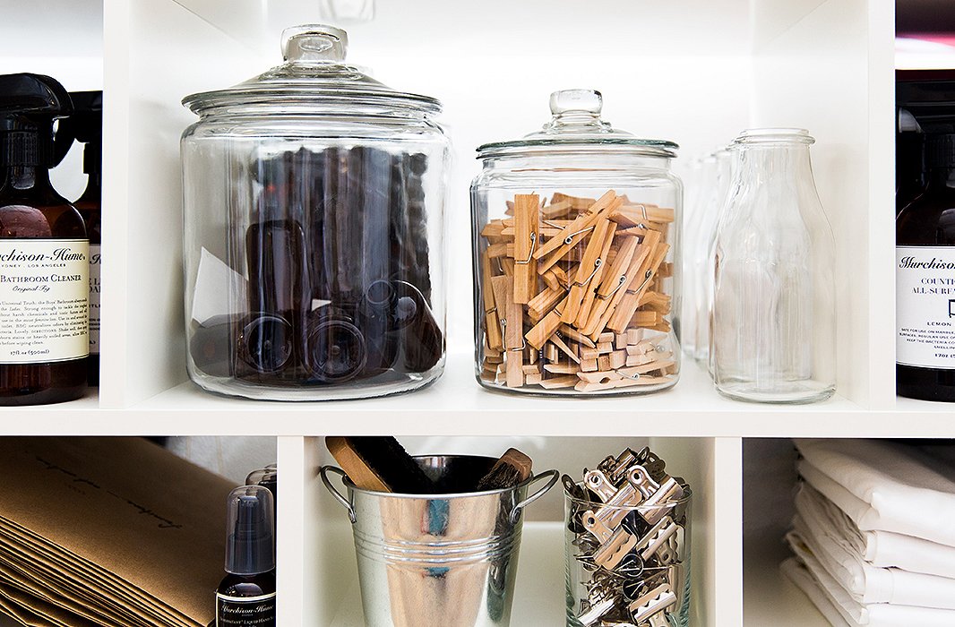 Glass containers act as both storage and a bit of stylish decor for the office shelves.
