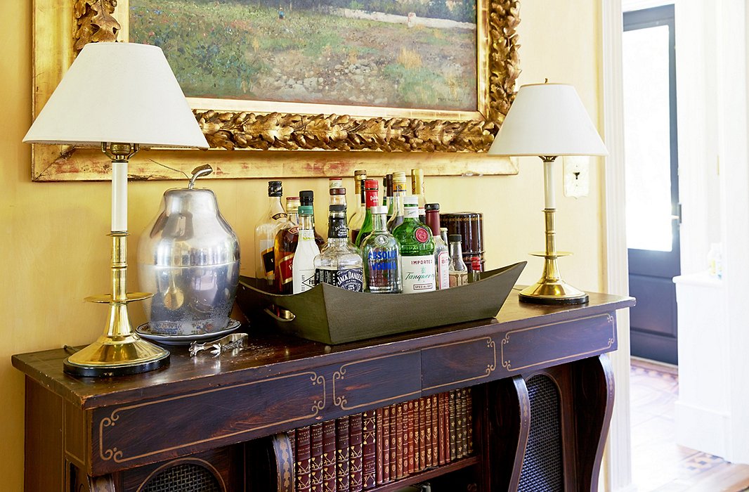 Set atop an antique cabinet, a self-service bar featuring a 1950s apple-shape ice bucket (found by John in a junk shop) sets a relaxed tone for entertaining.
