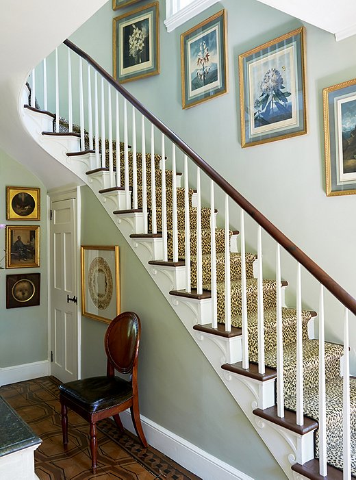 A leopard-print runner makes a playful contrast to a set of 18th-century botanical prints hanging above the staircase.
