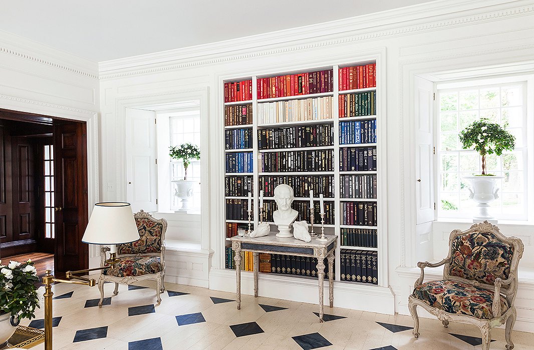 The effect of painted furnishings, painted floors, and a white paint custom-blended for the walls is totally fresh and sets this space apart from the dark wood hallway to the left.
