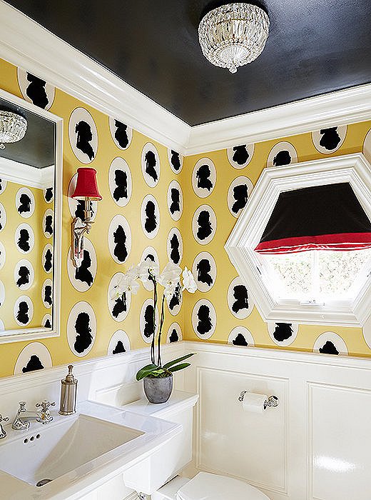The yellow, black, and red palette and traditional fixtures give the playful silhouettes of the wallpaper a more refined edge.
