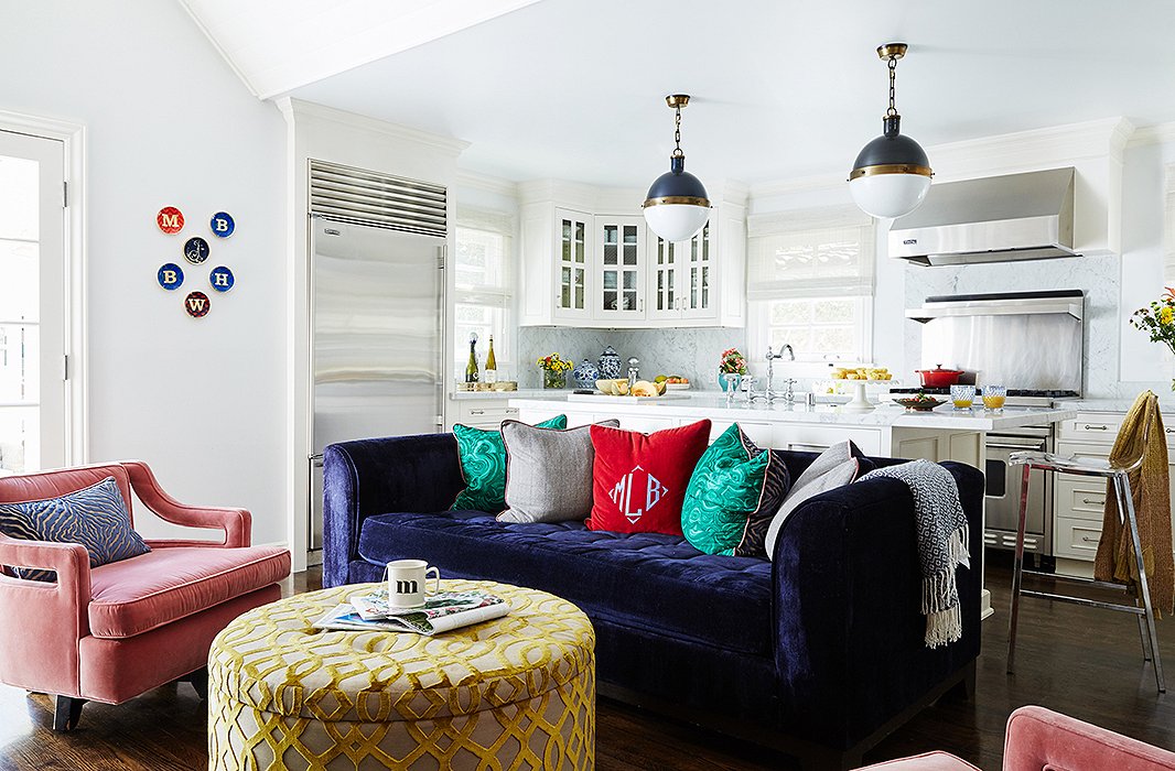 Jenn kept the macro palette white and the window treatments neutral, but her sense of playfulness is evident in the mix of pillows and personal family touches (note the monogrammed throw pillow and the initialed plates on the wall). The pendants over the kitchen counter are by Thomas O’Brien for Visual Comfort.
