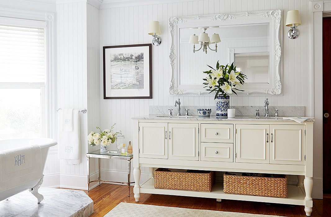 Awash in Carrara marble, the beadboard-walled master bath is a breezy departure from the rich tones and textures that define the rest of the house.
