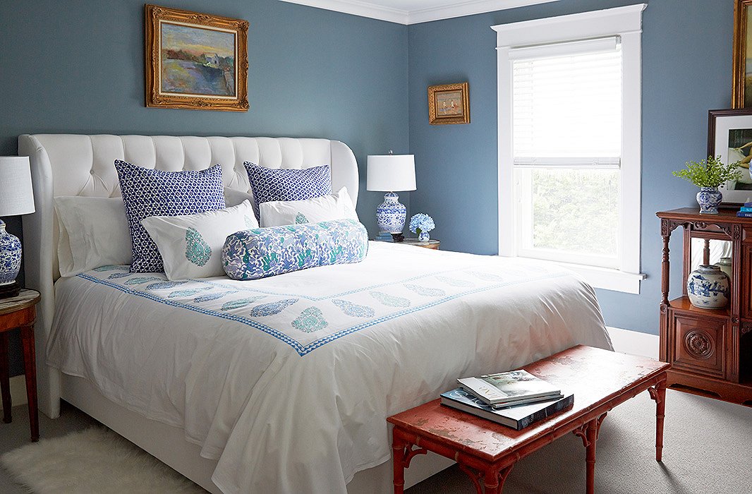 In the master bedroom, a tufted bed from One Kings Lane is dressed in block-printed bedding Delaney picked up on a trip to Jaipur, which adds lightness to a room otherwise filled with antique case goods and serious art.
