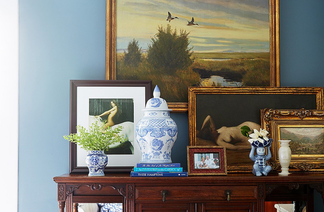 While art is hung elsewhere with precision and picture lighting, a looser vignette takes shape on the Victorian walnut sideboard in the master bedroom, where pieces from the couple’s stately collection mix with playful tokens that speak to Delaney’s publishing-world pedigree.
