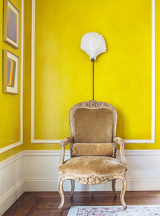 The chair, a French fauteuil in Louis XV style that Bachmann bought in London, is paired with a shell sconce from Past Perfect, a local vintage boutique.
