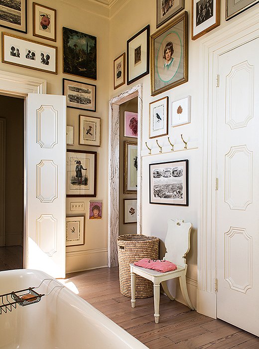 Sara converted this former bedroom into a master bath, painted the walls a creamy mascarpone white, and covered the walls with family portraits and art. “Kitchens and bathrooms are great places to display things that are more personal.”
